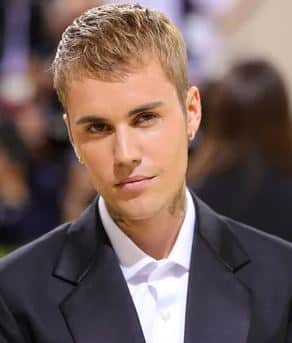 Justin Bieber performing on stage with a crowd cheering