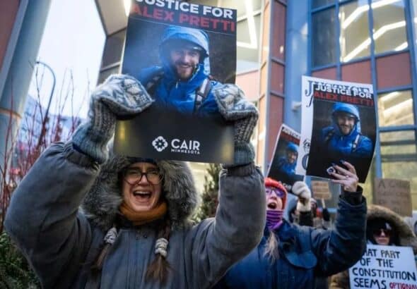 Protesters holding signs demanding justice for Alex Pretti after fatal shooting by border agents in Minneapolis