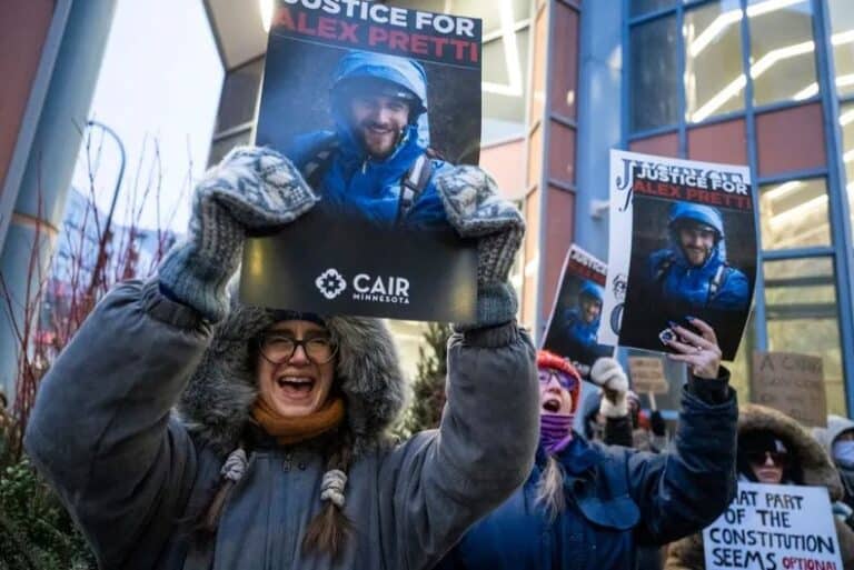 Protesters holding signs demanding justice for Alex Pretti after fatal shooting by border agents in Minneapolis